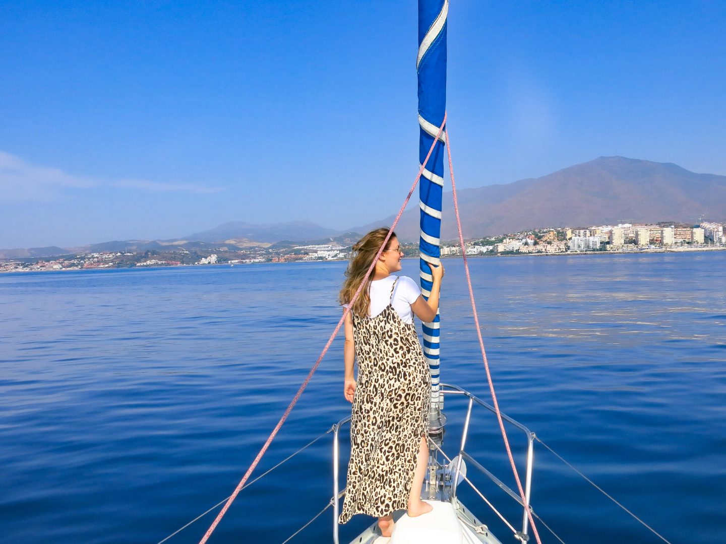 Woman on a boat, trying to spot dolphins off the shore of Andalusia. One of the day trips offered by Kempinski Hotel Bahía, Spain 